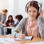 Young student writing a transcript.