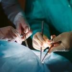 Close-up of hands surgeons holding medical instruments.