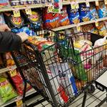 Pushing a cart filled with groceries on the snacks aisle inside a supermarket in Wilmington, Delaware.