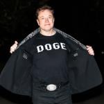 Elon Musk reveals a DOGE t-shirt and a Tesla belt buckle before entering the White House on March 9, 2025.
