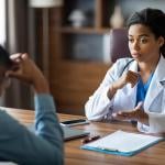 Black female doctor having a conversation with her patient.