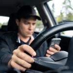 Man distracted texting on his smartphone while driving.