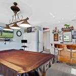A pool table covered in leather in a game room.