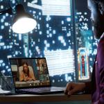An employee working from home in a videocall session with the CEO and other employees.