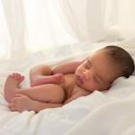 Newborn baby sleeping in bed.