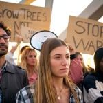 A group of diverse people protesting against war in silence outdoors.