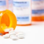 Prescription tablets spilling from bottle.