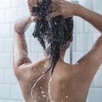 A woman shampooing in the shower.