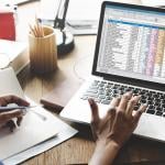 Young female entrepreneur looking at a spreadsheet report.