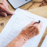 A senior person signing a last will and testament document.