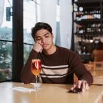 Young man who was ghosted by his date sits alone disappointed in a restaurant.