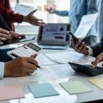 Business team in a busy meeting discussing figures and reports.