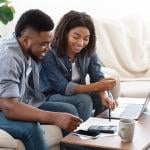 A black couple engaged in a discussion about finances.