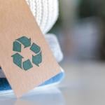 Knitted clothes with a craft tag showing the recycling symbol.