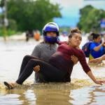 A man carries a pregnant woman through a flooded road in La Lima, Honduras after the low pressure system "Eta" caused heavy rainfall throughout the region.