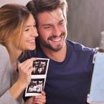 A young couple sharing ultrasound photographs while in a virtual call with loved ones.