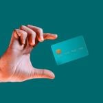 Hand reaching for a credit card mid-air.