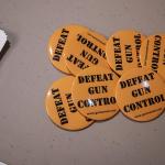 Orange "Defeat gun control" buttons set out on a table for people after they sign their name to give to legislators working on gun control bills.