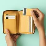 Person taking out a credit card from a wallet.