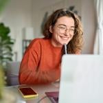 Young Gen Z professional at home watching a webinar.