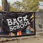 A black "Back to School" banner hangs outside a New York pre-school enrolling a pre-kindergarten class.