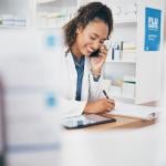 A pharmacist taking a call and listing a customer's order.