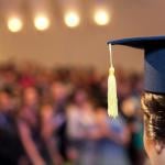A graduating student facing the ceremony crowd.
