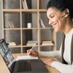 Young female professional engaged in a virtual meeting while working from home.
