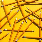Scattered pencils on a yellow background.