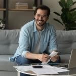 Happy man holding credit documents.