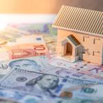 House model on various of international banknotes on the table. 