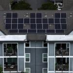 Aerial view of solar panels are on the roof of an apartment complex in California.