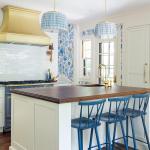 French style country kitchen with white tile, dark countertops and blue and white wallpaper accents.