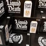 Black boxes of Liquid Death canned mountain water grocery store display.