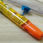 A discarded Epipen auto injector lying beside a sink.