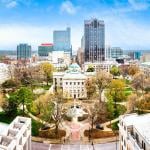 Aerial view of the North Carolina State Capitol and Raleigh skyline.