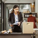 Young businesswoman preparing her work items to put in a box after being laid off.