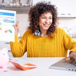 A woman happily holding up a good credit score report.