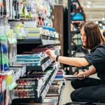 A young woman choosing school supplies at a supermarket.
