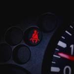 A car's dashboard with the seatbelt warning light turned on.