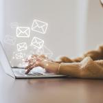 A marketing professional working on her laptop illustrated with graphics of email and newsletter.