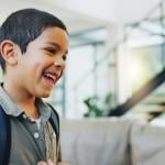 A young boy getting ready to go to school talking with his dad.