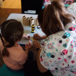 Maggi, a child care provider in New Mexico, with a preschooler in her care working on an art project.