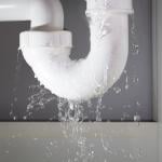 Close-up of a water pipe from under the sink leaking.
