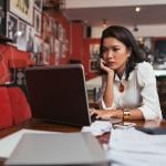 A female bar owner using her laptop to pay business expenses online.