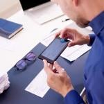 Business employee taking a photo of a deposit check.