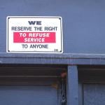 A "We reserve the right to refuse service to anyone" signage at a restaurant.