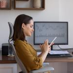 A female finance trader using her smartphone at work.