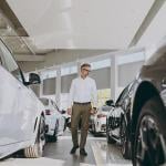 Man looking around a car dealership.
