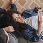 Young couple at home browsing information using a phone.